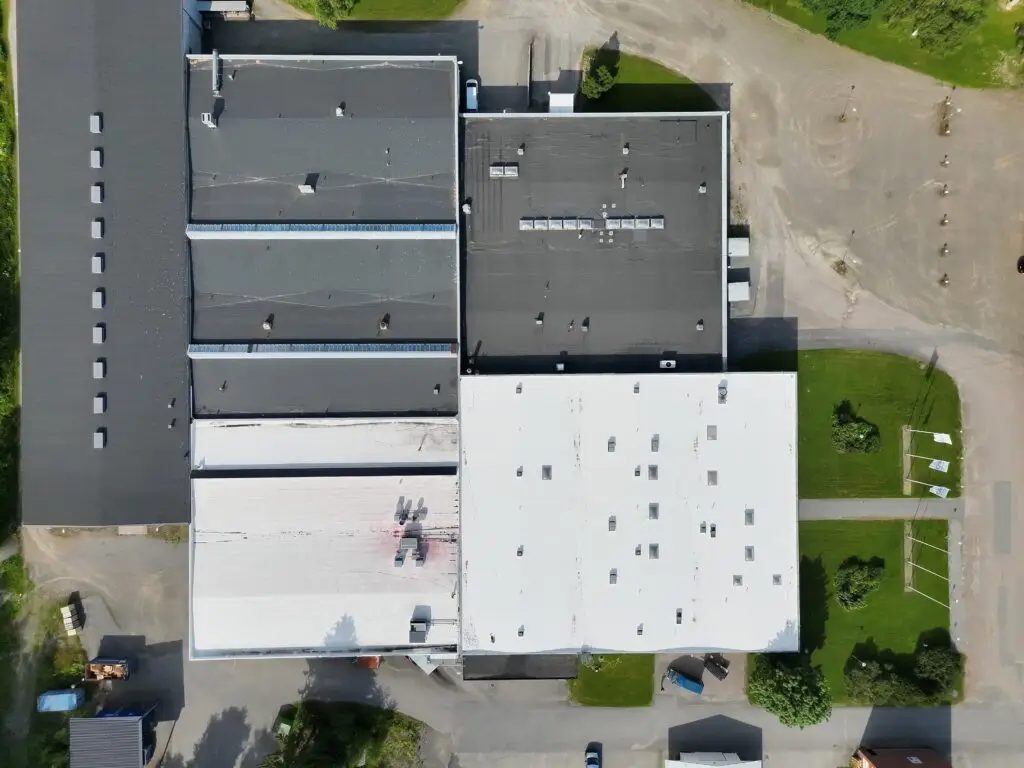 Aerial view of industrial roofs, one coated white